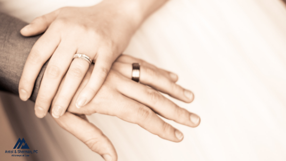 Woman's hand over a man's right after getting married. Both hand have wedding rings.