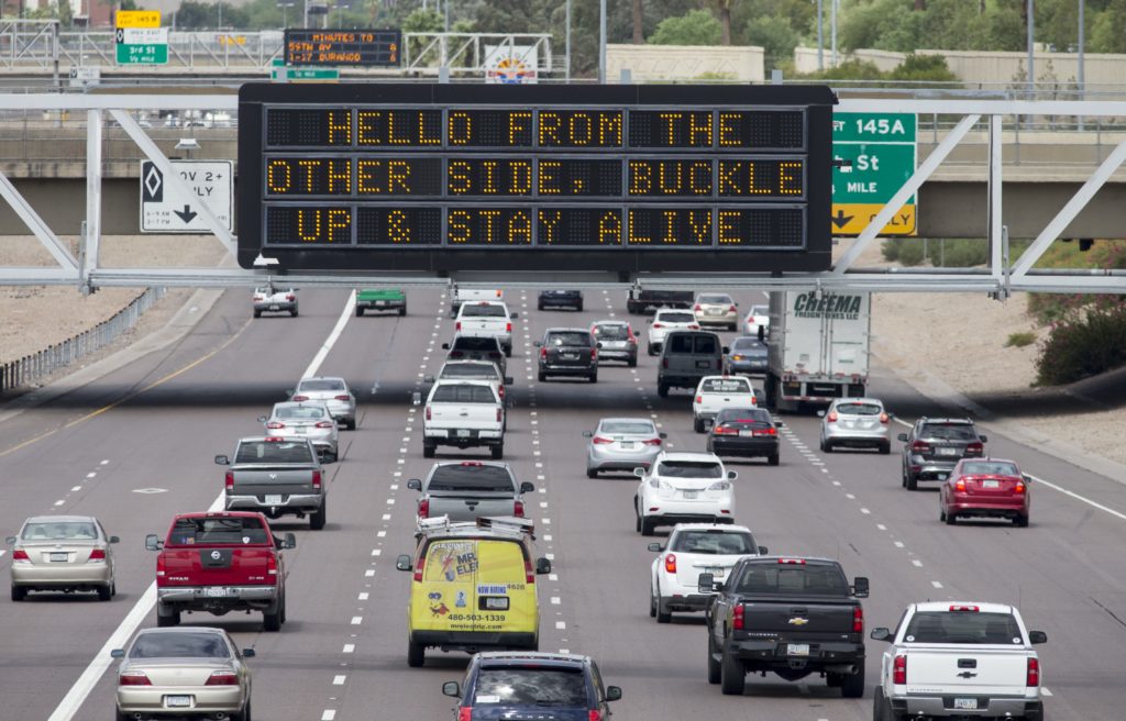 ADOT freeway sign that says, "Hello from the other side, buckle up & stay alive"