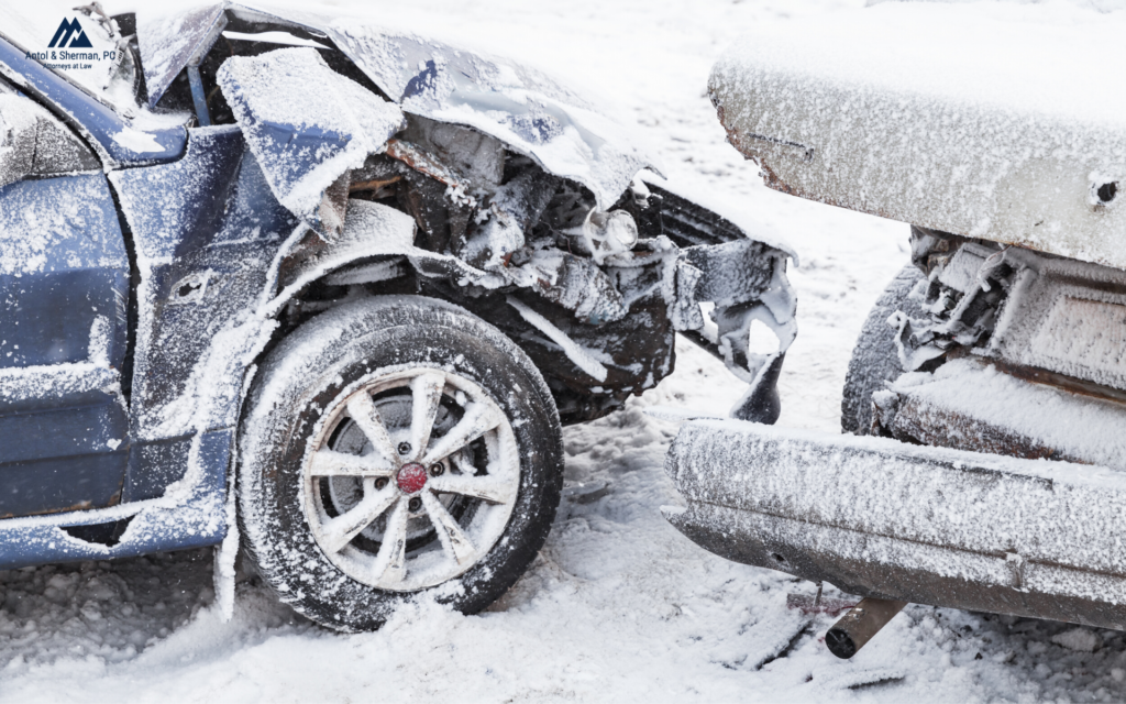 Two vehicles in an accident on a snowy road.