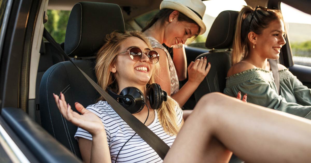 Group of friends driving along in car