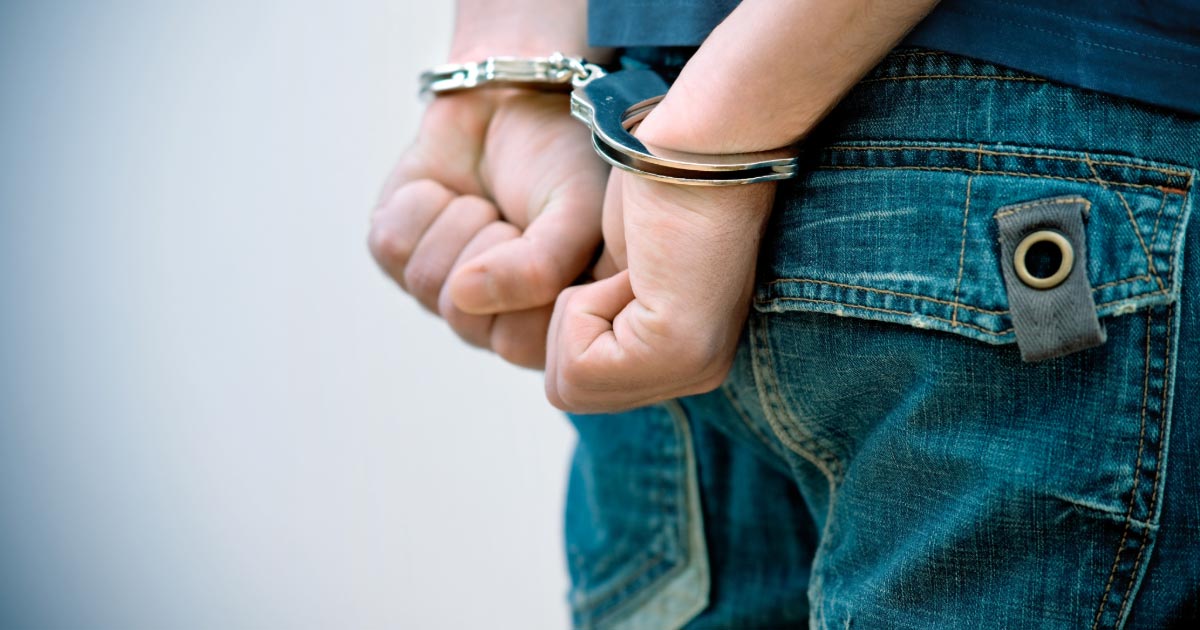 Teen boy handcuffed behind his back