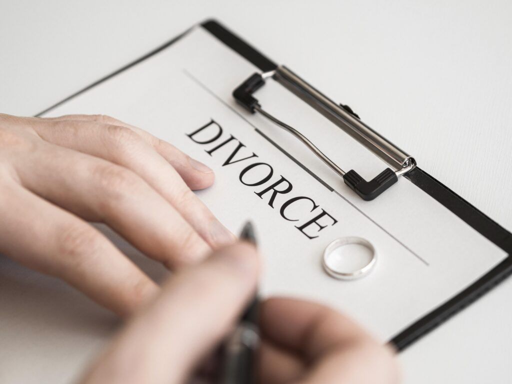 close-up of hands filling out divorce paperwork