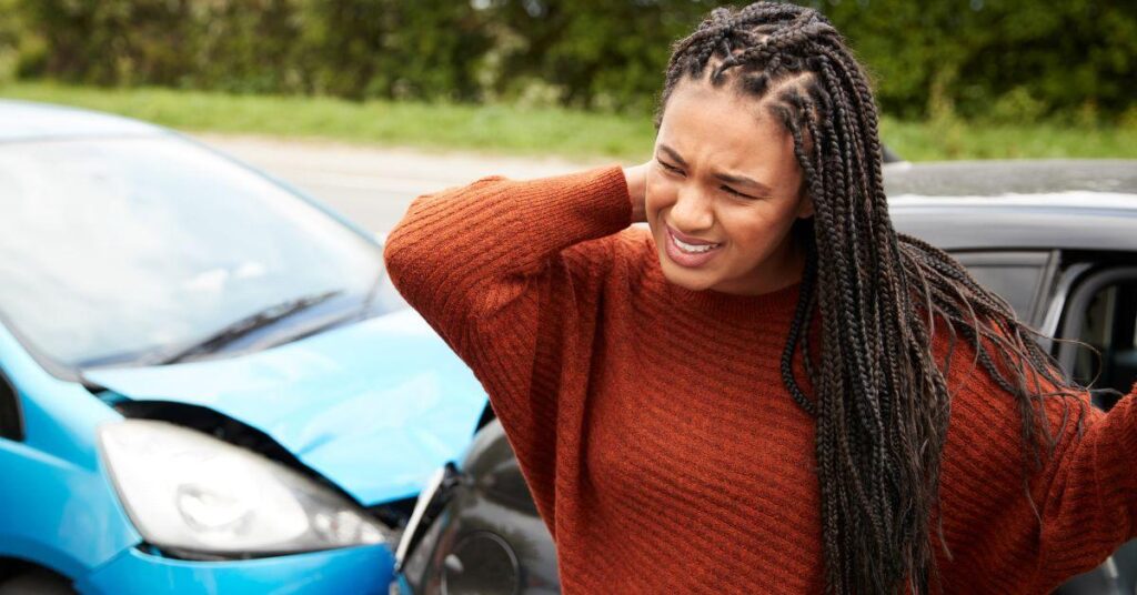 woman holding her neck after being injured in a car accident