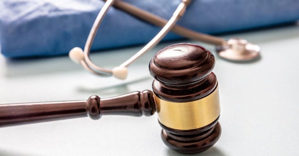 gavel next to medical scrubs and stethoscope