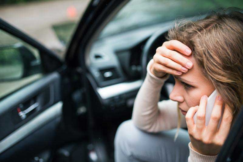 Worried Woman Sitting in Car Talking on Phone