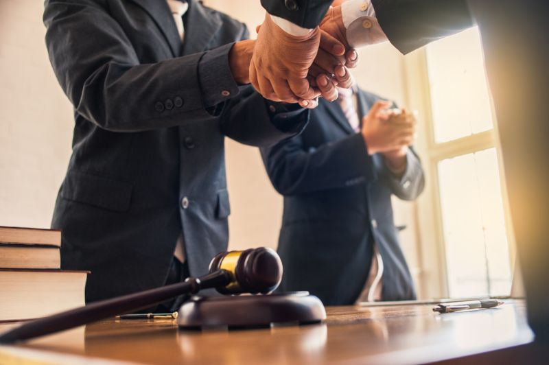 Lawyers shaking hands in a courtroom