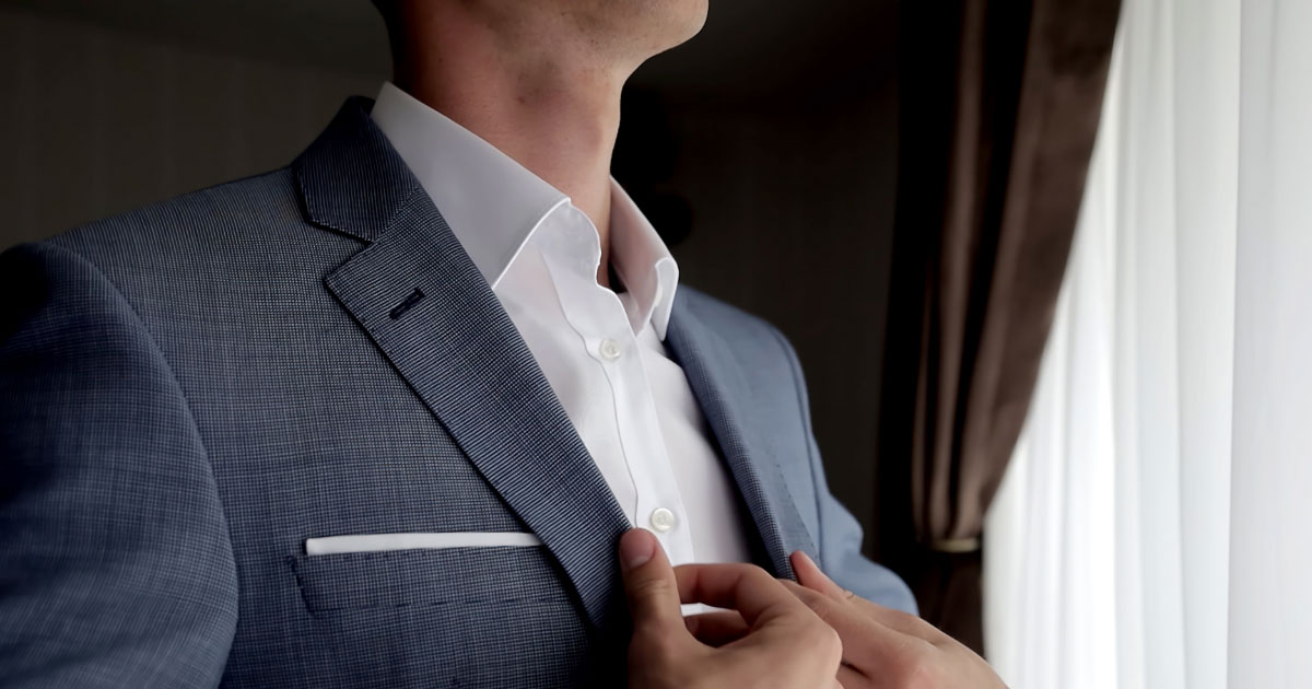 Young man putting on tailored suit