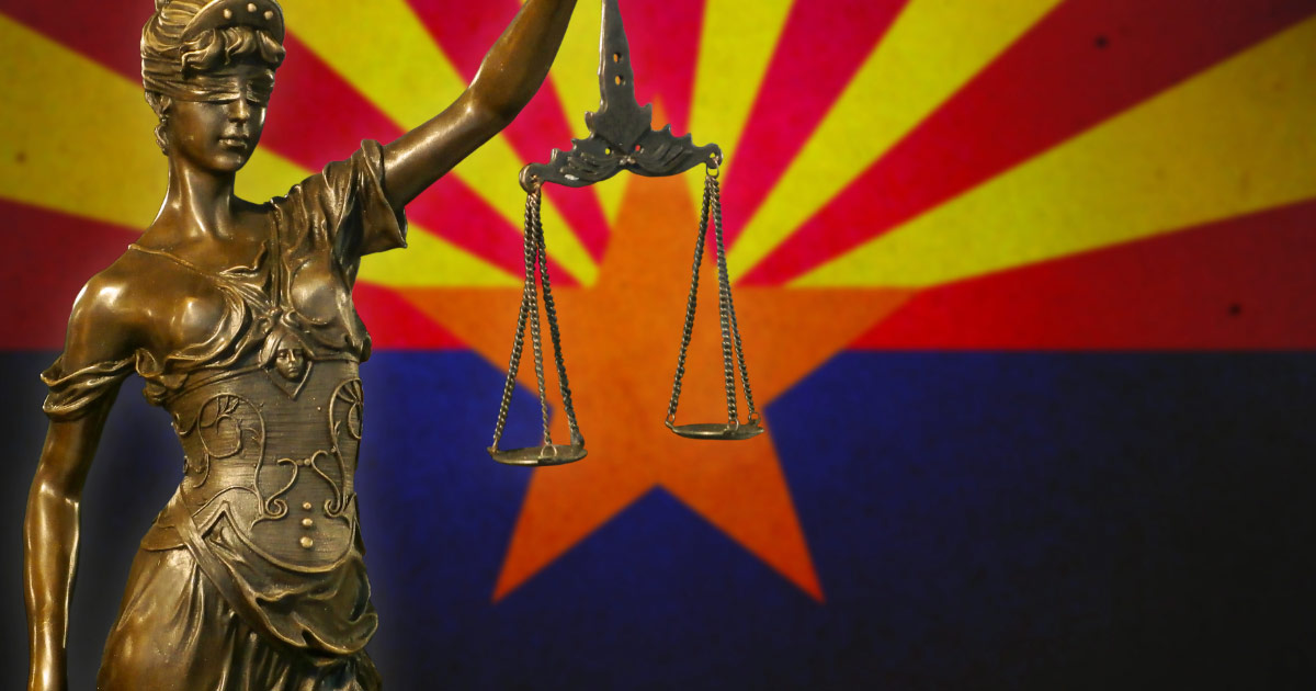 Scale of justice in front of Arizona flag