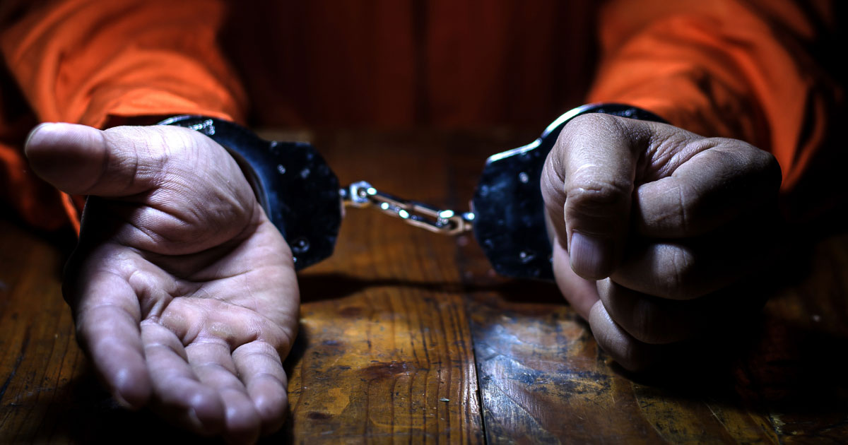 Man wearing handcuffs and orange jumpsuit